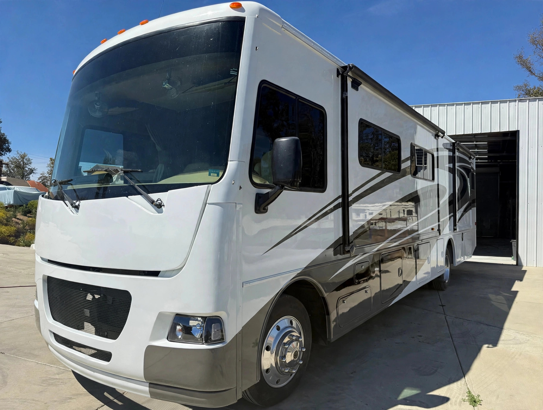Freshly repainted white motorhome outside the Performance RV shop