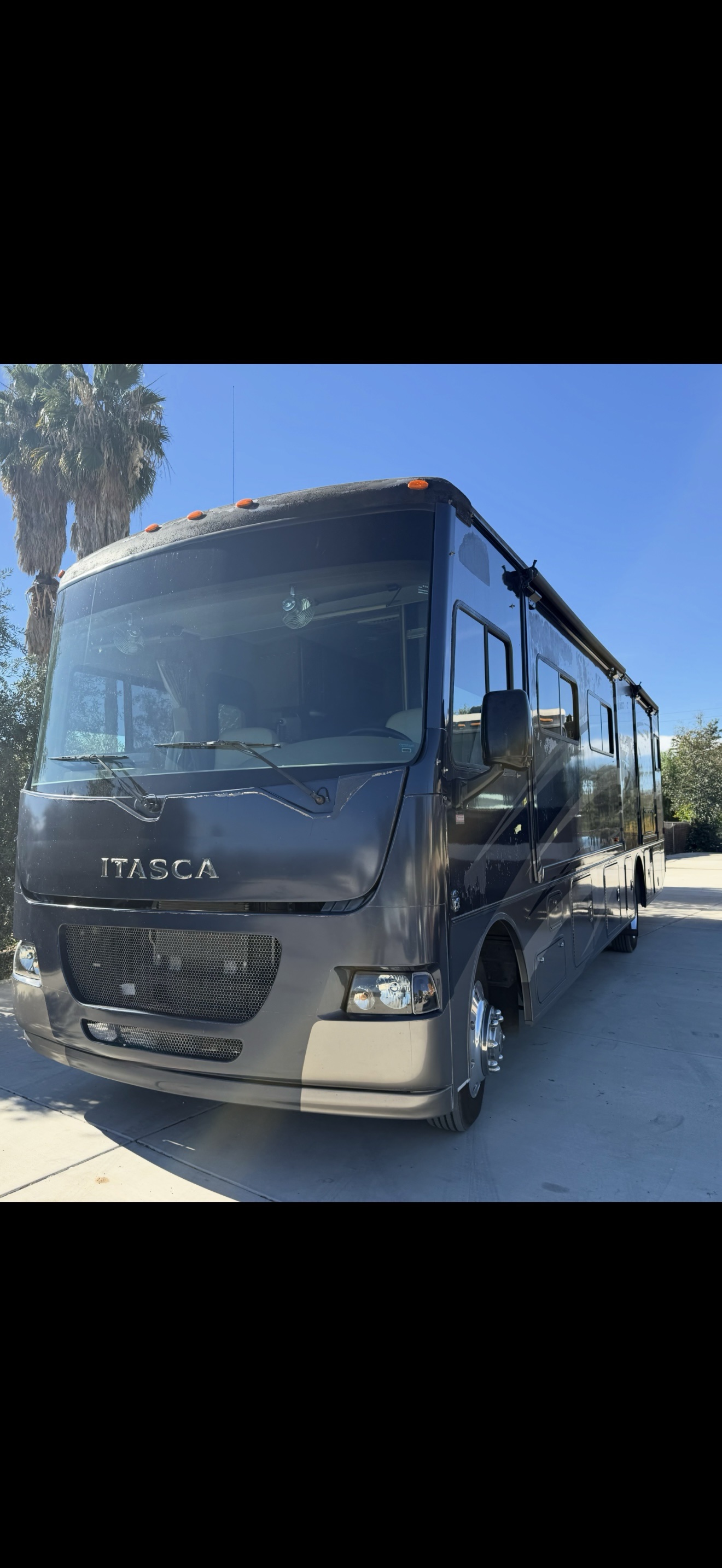 Full weathered dark Itasca motorhome before repainting